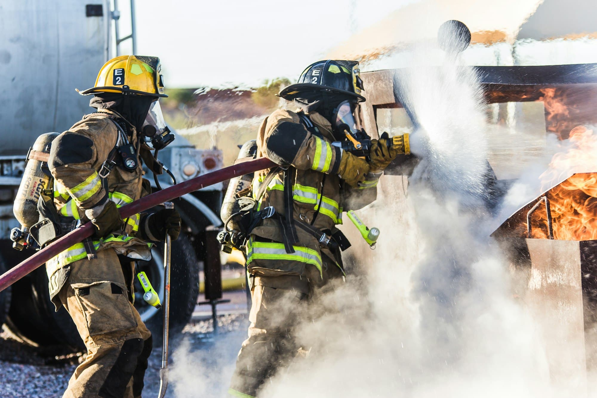 Firefighters tackling a fire with a hose