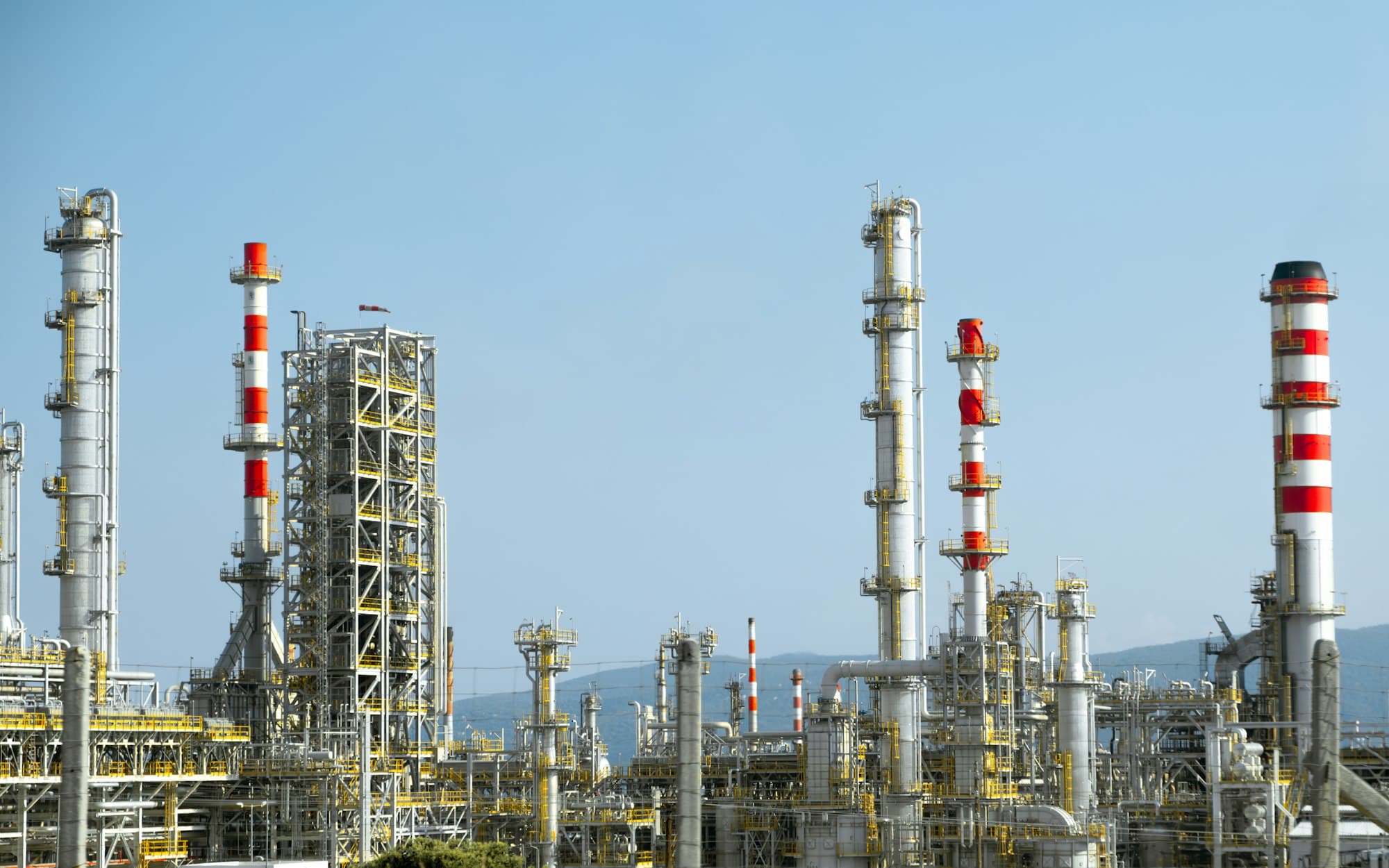 A refinery with distillation columns and red and white stacks